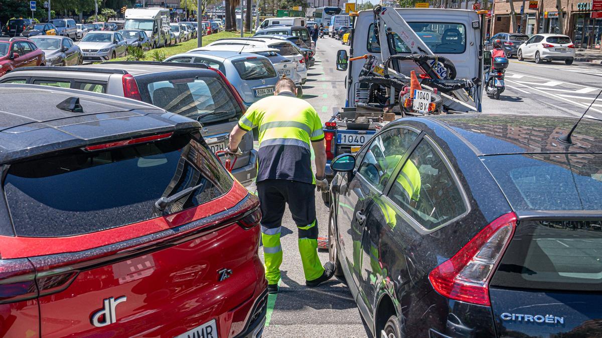 Una grúa retira unos coches mal aparcados en Barcelona.