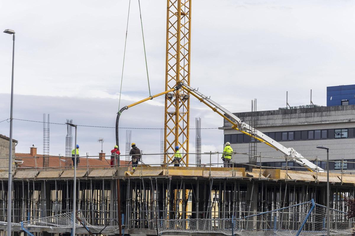 Operarios trabajan en un edificio en construcción en el barrio de O Restollal, en Santiago.