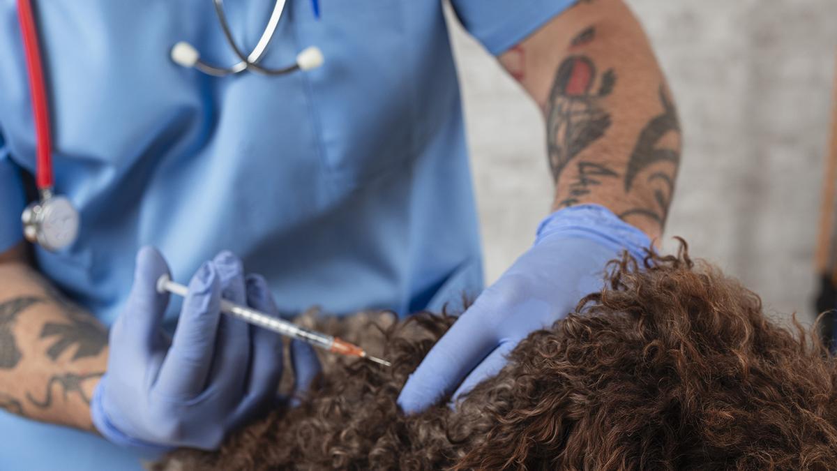 Un veterinario pone una vacuna a un perro