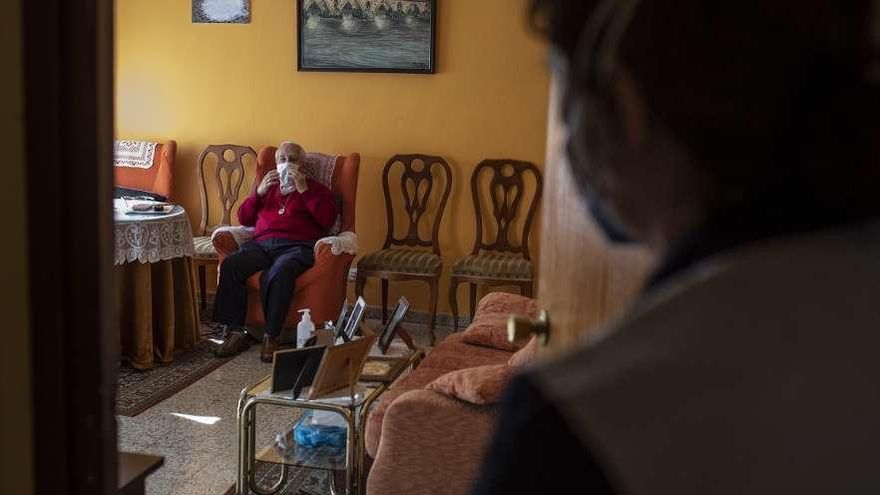 Begoña, trabajadora de la ayuda a domicilio, en la casa de José durante una jornada de trabajo.