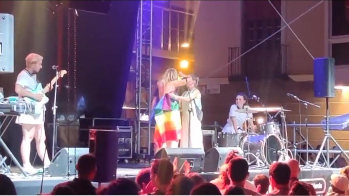 Una persona de la organización tapa a Rocío Saiz con una bandera arcoíris durante su recital en Belluga. LA OPINIÓN