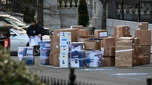 Un trabajador lleva una caja para ser transportada, en el exterior de la Casa Blanca.