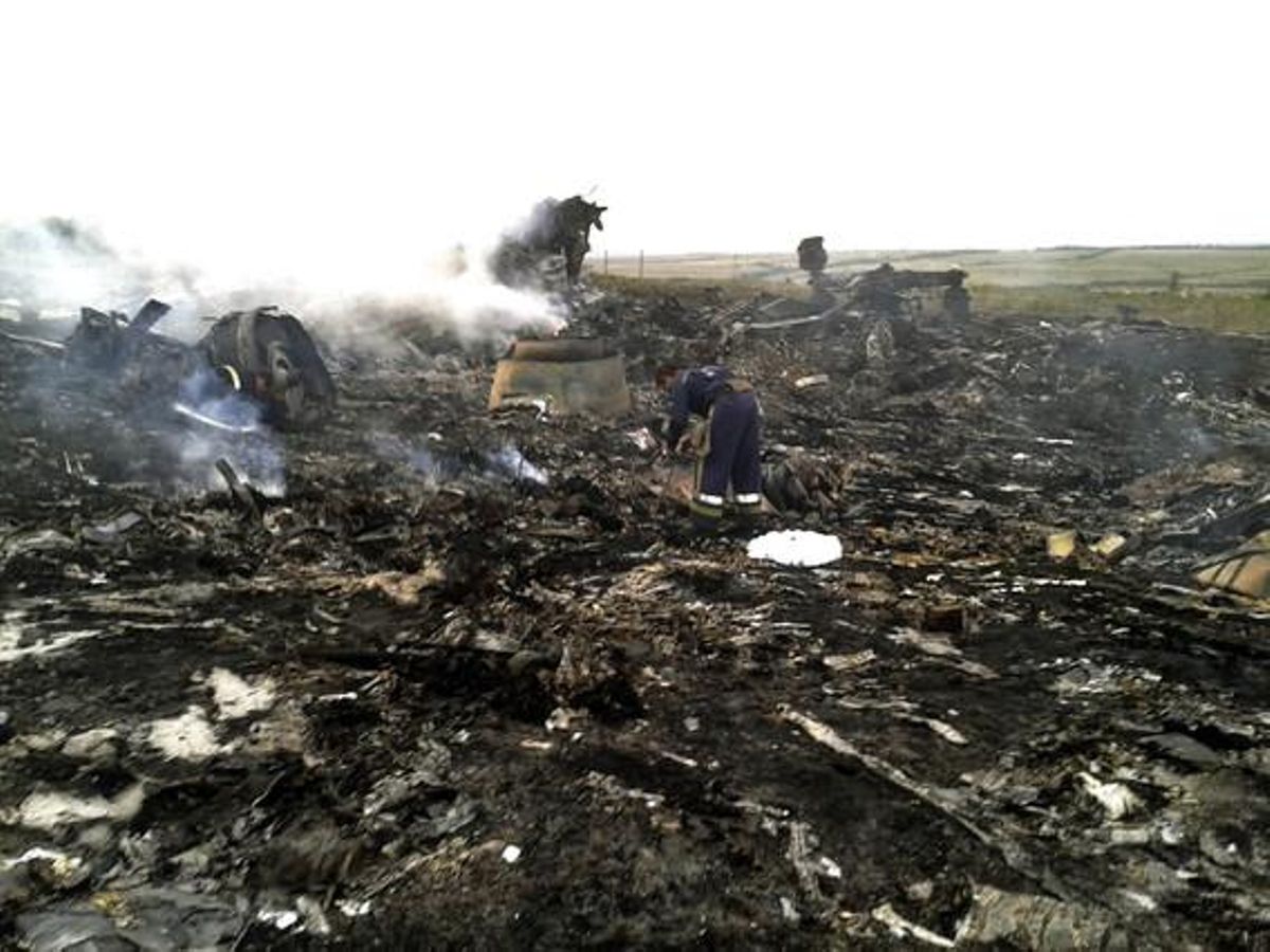 Membres dels equips d’emergències inspeccionen les restes de l’avió sinistrat aquest dijous a l’est d’Ucraïna.