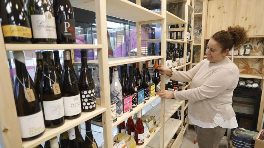 Sonia Martínez coloca una botella de vino en la estantería de su nuevo negocio en la plaza. | R, Solís