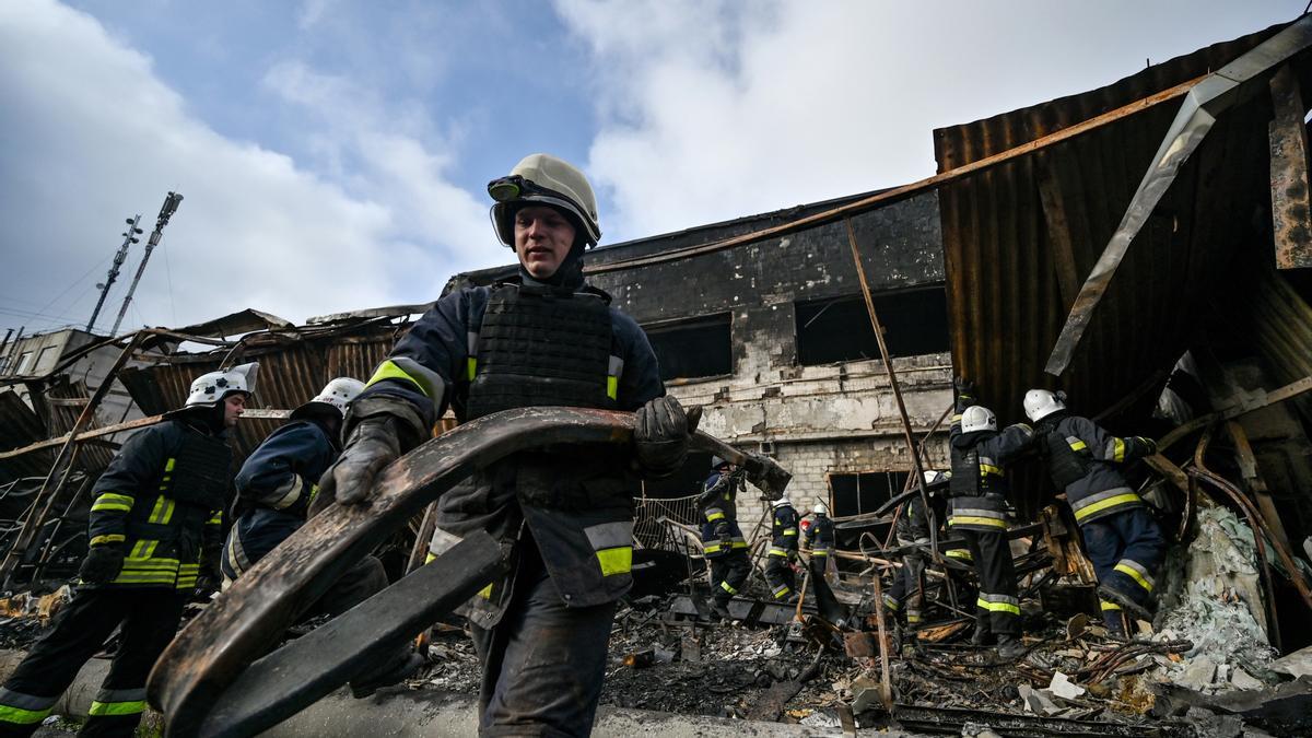 Servicios de emergencia se afanan en labores de rescate tras la caída de un misil ruso en Zaporiyia.