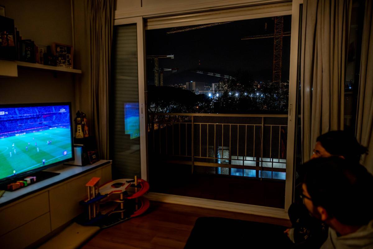 Sergio y su mujer, vecinos del Camp Nou, miran un partido de fútbol en su casa.