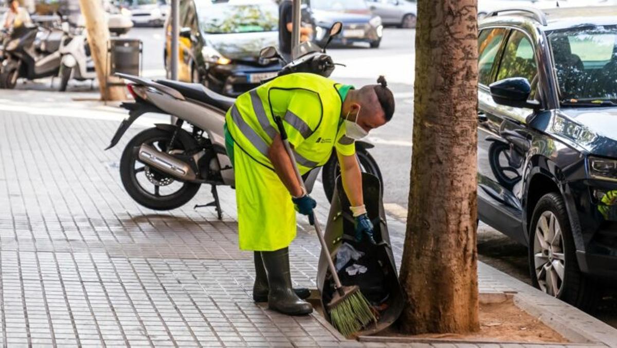Un operari escombrant en un carrer de la ciutat Un operari escombrant en un carrer de la ciutat