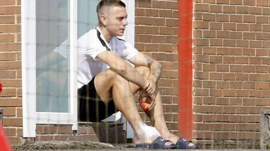 Juan Rodríguez observa el entrenamiento sentado, con hielo en el tobillo derecho, ayer, en Mareo.