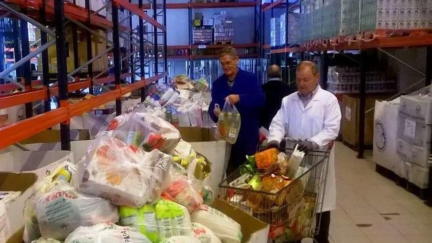 Varios voluntarios recuentan los alimentos donados. // FdV