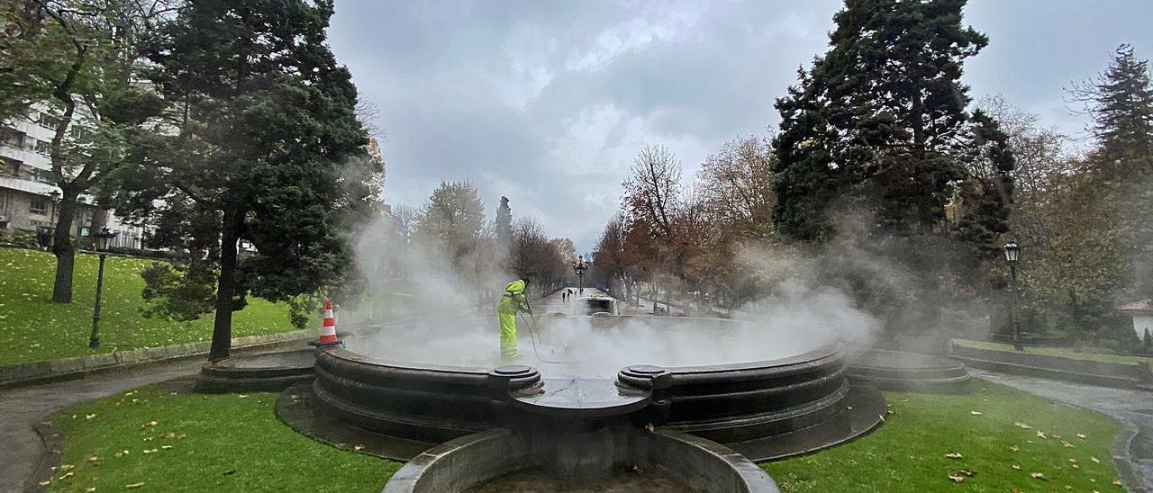 Un operario municipal, poniendo a punto la Fuentona del Campo, en el paseo del Bombé. | LNE