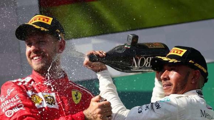 Hamilton y Vettel celebran su primer y segundo puesto en el podio.