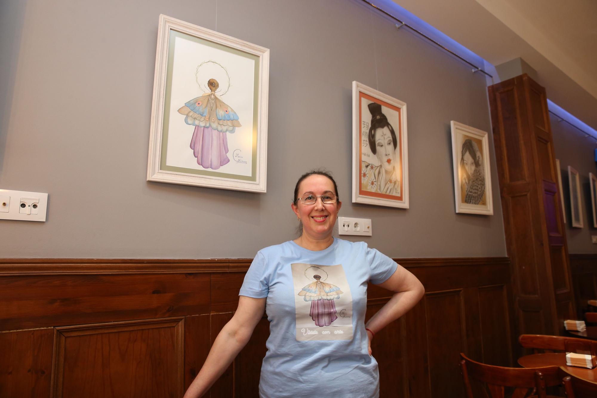 Marisa Galiñanes, ante algunos de sus cuadros y la camiseta de &quot;Vístete de arte&quot;.