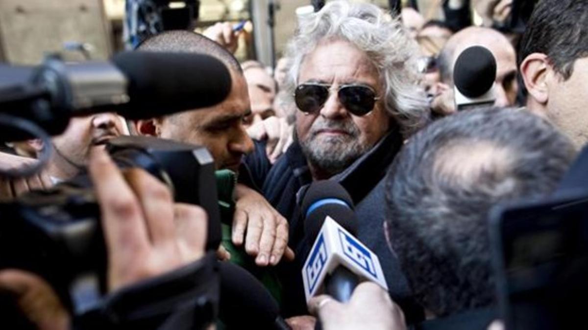 Grillo abandona entre una nube de periodistas el Hotel Universo de Roma, este lunes.