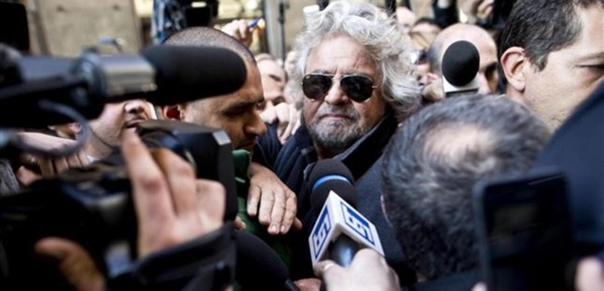 Grillo abandona entre un núvol de periodistes l’Hotel Univers de Roma, aquest dilluns.