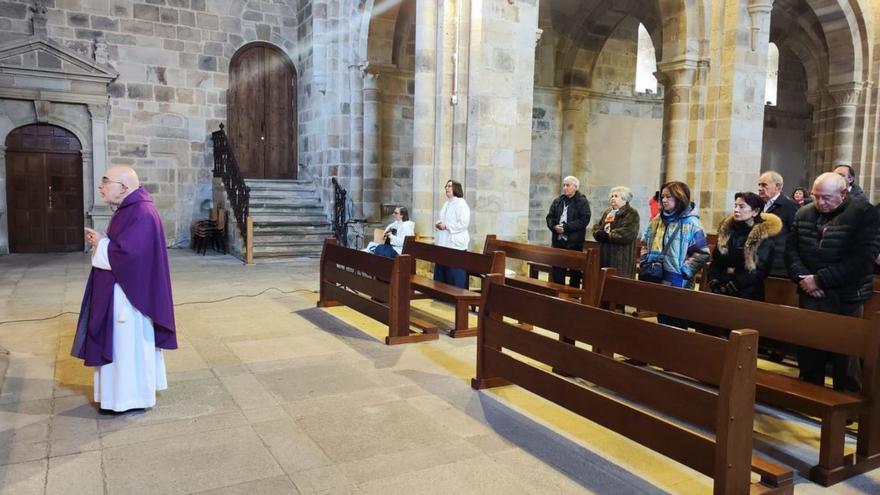 El padre Miguel Ángel, mirando al altar al finalizar la misa en la iglesia de Valdediós, con las dos hermanas en los primeros bancos de su derecha. | A. G.-O.