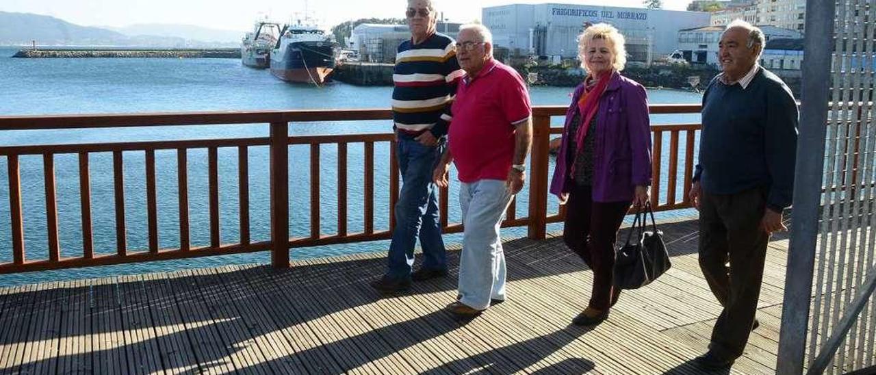 Desde la izquierda, los marineros Eugenio Román, Ramón Marcos y Jesús Cordeiro, junto con Carmen Juncal (viuda de un tripulante que trabajó en la flota noruega), ayer tarde en el puerto de Cangas. // G. Núñez