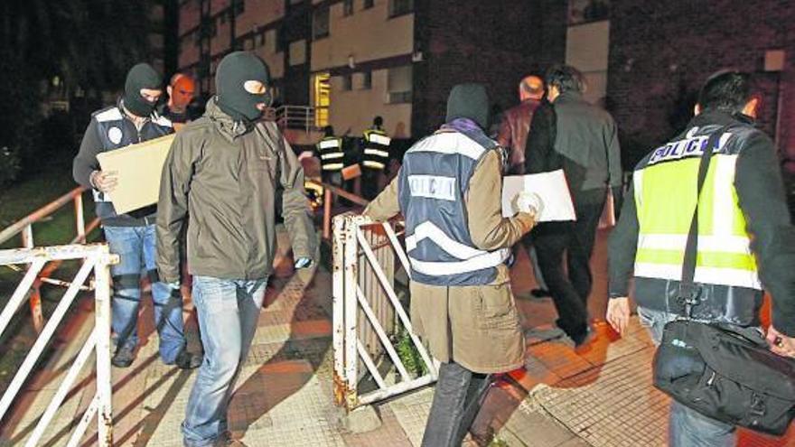 Agentes salen del edificio tras realizar el registro, ayer en Vigo. / marta g. brea