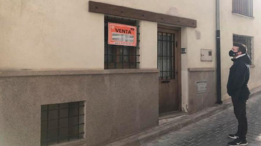 Un joven de Morella observa el cartel de una vivienda que está a la venta en la localidad.