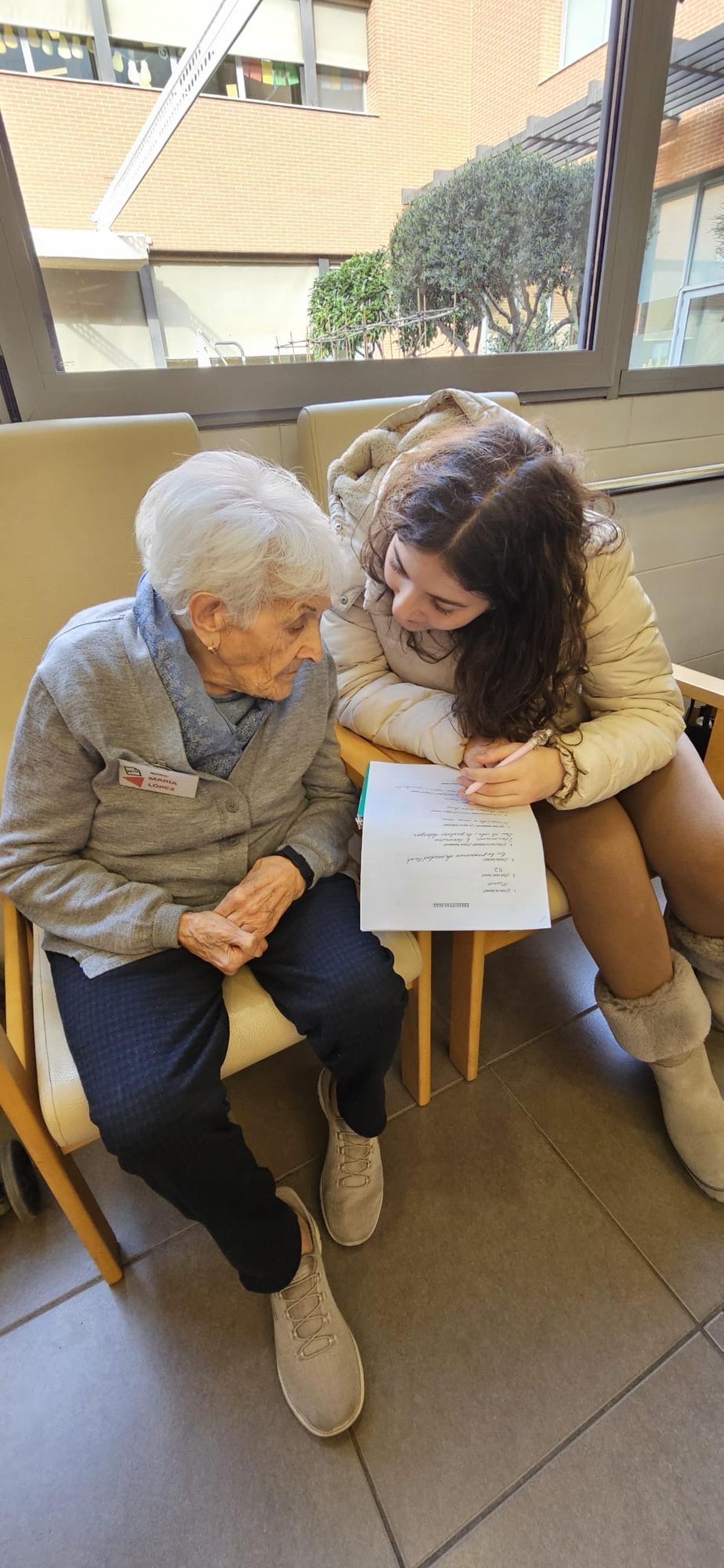 La jove Elena Hovahnnisyan entrevistant a María López, de 92 anys, al Centre de Dia de l'AFAV.