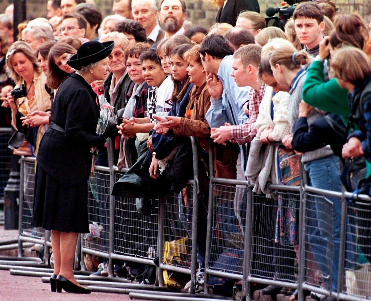 1997 La reina Isabel II de Inglaterra conversa con varios jóvenes tras acercarse al público congregado a las puertas del Palacio de Saint James en Londres (Reino Unido) donde la monarca presentó sus respetos a la princesa Diana de Gales el día 5 de septiembre de 1997.