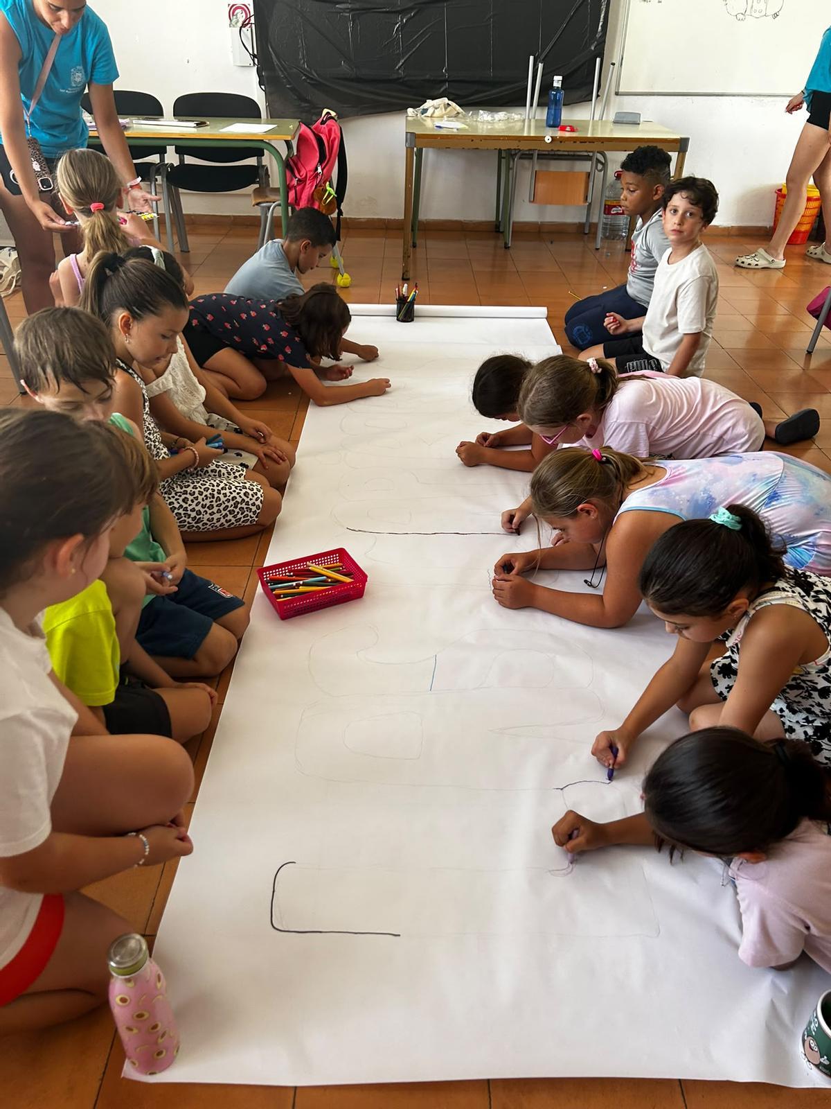 Asistentes de la escuela de verano trabajan juntos en un cartel