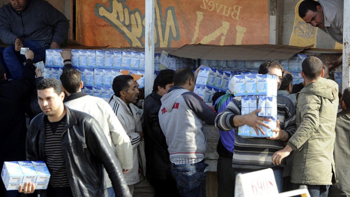 Varias personas se hacen con provisiones de leche, en la capital tunecina.