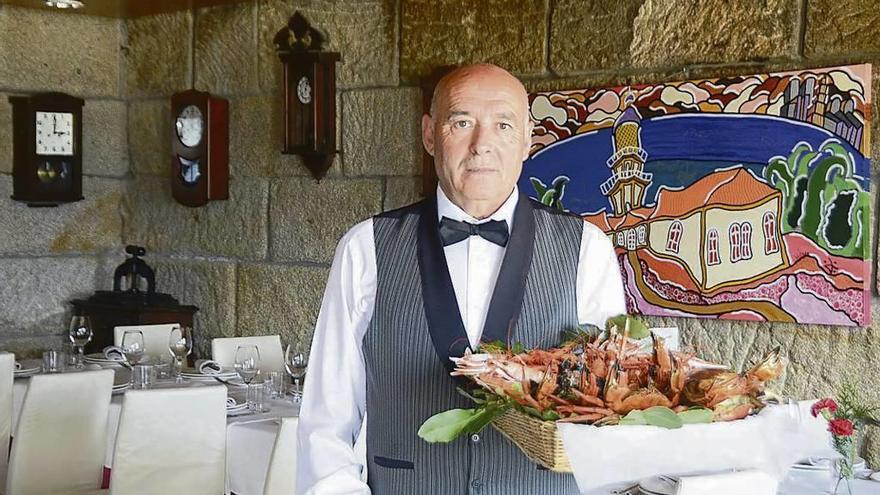 Manuel Lareu posa con una cesta de mariscos, ayer, en el comedor de A Centoleira. // Gonzalo Núñez