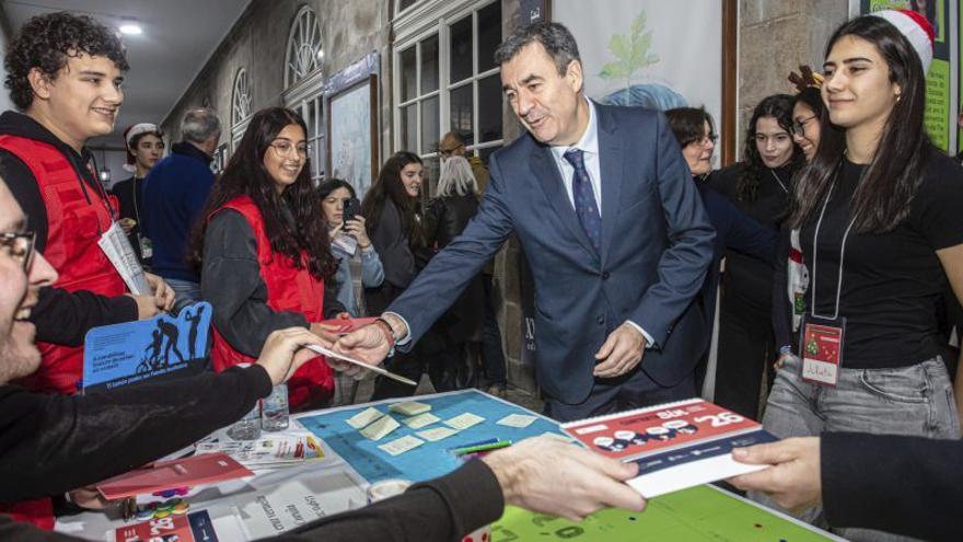 El conselleiro de Educación, Román Rodríguez, ayer, en el Mercado Solidario de Nadal del IES Rosalía de Castro.  | |  X. G.