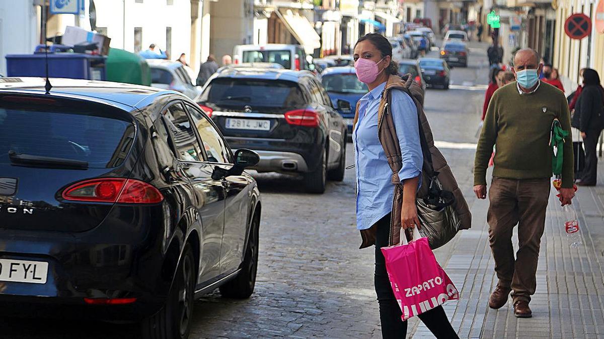 Una vecina trata de cruzar de acera en la calle Puerta de Aguilar, una de las vías con más tráfico rodado.