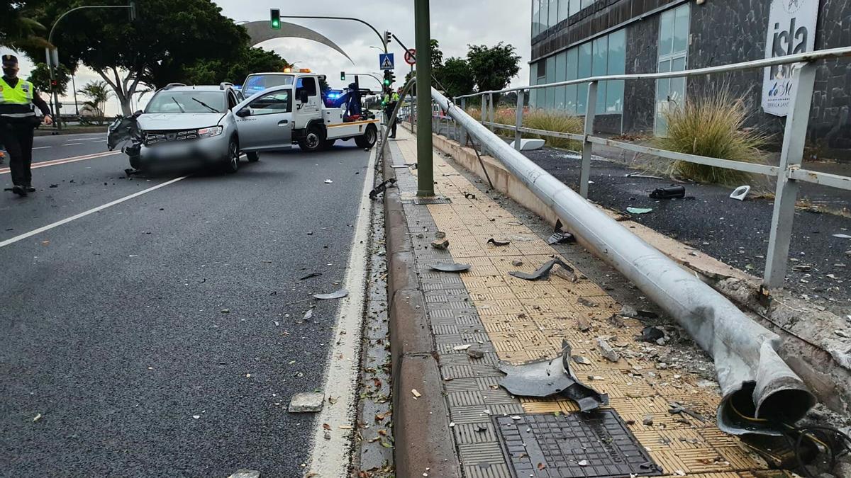 La farola en el suelo tras el accidente y, a la izquierda, el coche siniestrado en la Avenida de la Constitución de Santa Cruz de Tenerife.