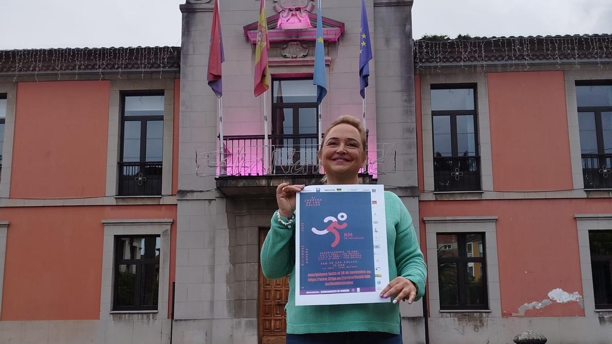 Patricia Redondo, edil de Deportes, con el cartel promocional de la carrera.