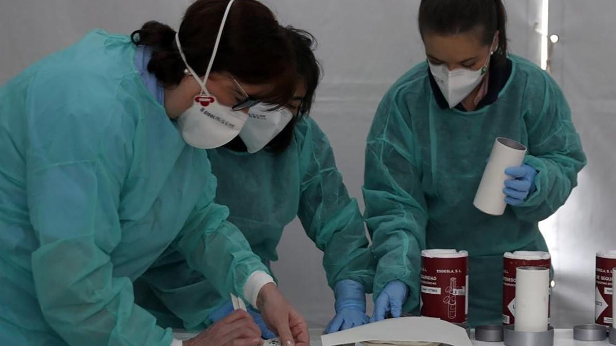 Enfermeras trabajando en un hospital con batas y mascarillas de protección.