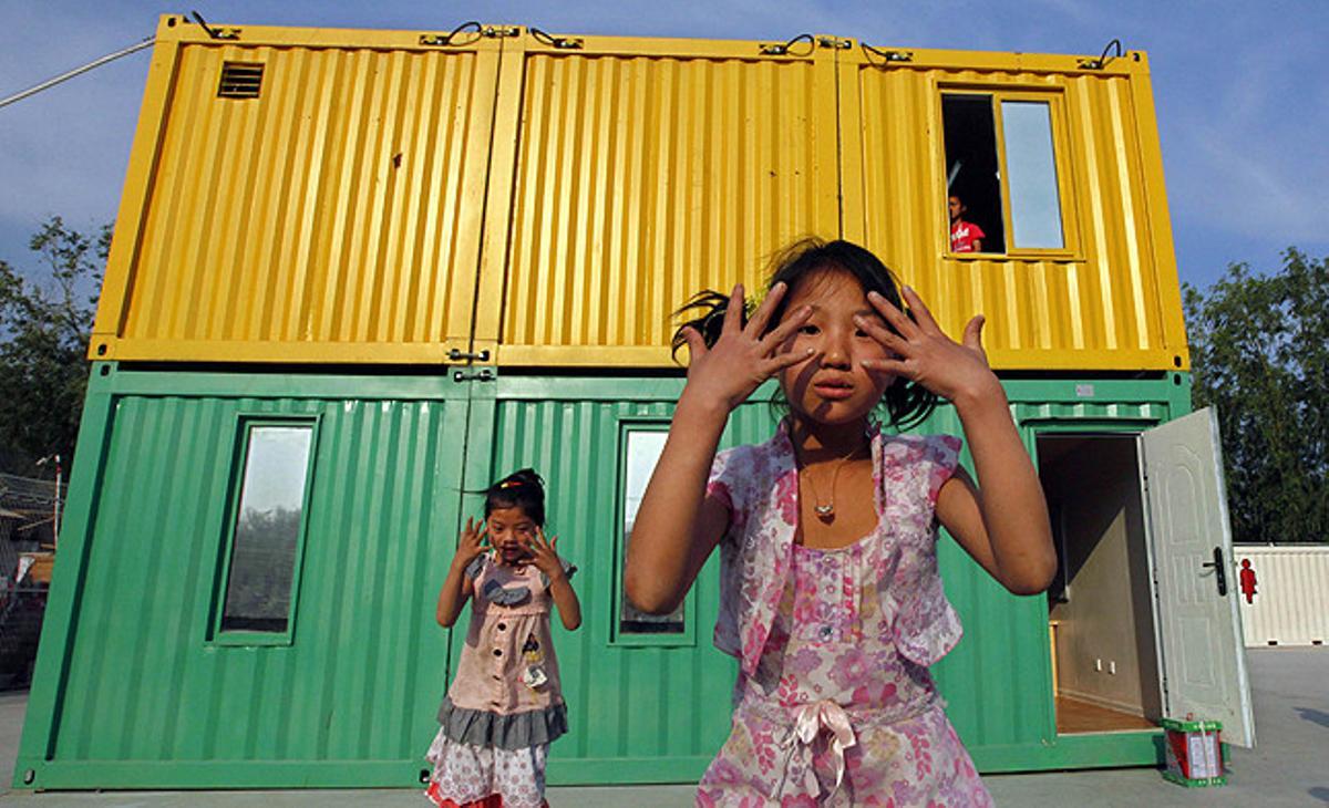 Nenes jugant davant dels contenidors que els serveixen de classe en el programa iniciat per l’organització ’Compassion for Migrant Children’ a Pequín (Xina).
