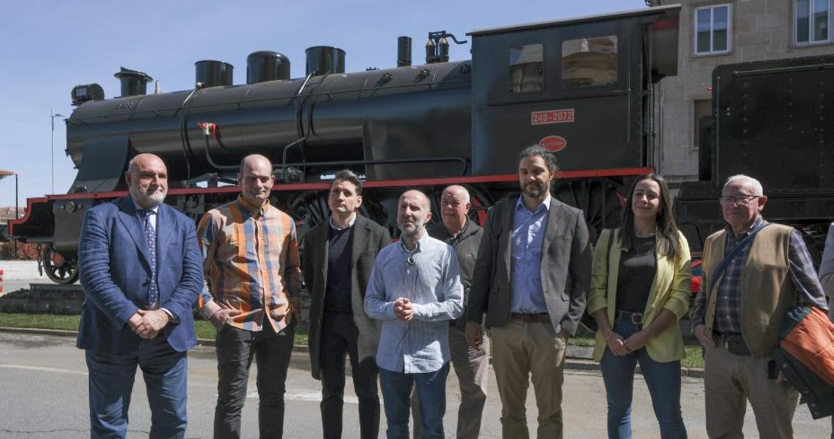 El alcalde, con ediles y vecinos, ante la locomotora ya restaurada. | ROI CRUZ