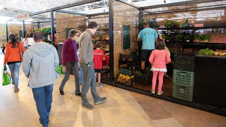 Los clientes seleccionan frutas y verduras en cajas apiladas en el suelo en los puestos del mercado.