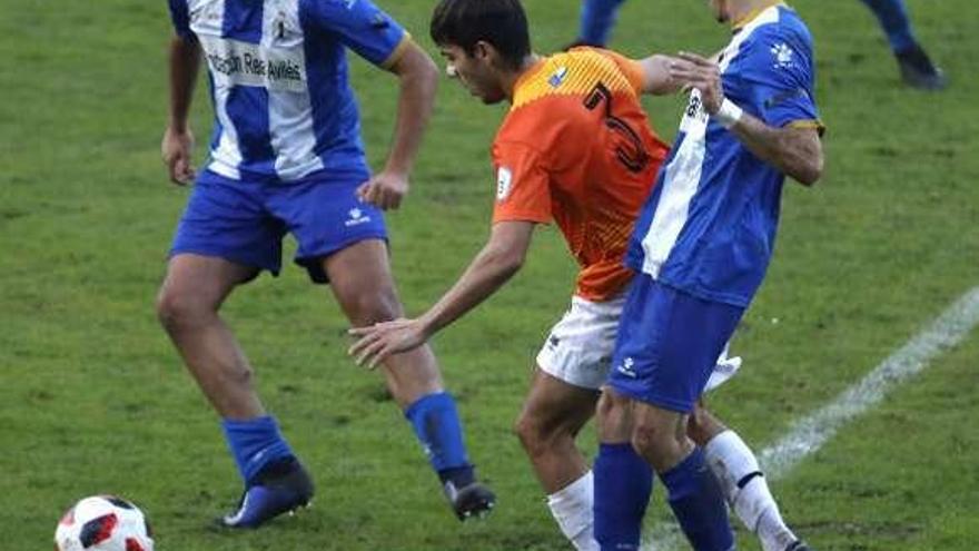 A la izquierda, Carlos Núñez presiona a un jugador del Caudal junto a su compañero Paulo en el partido de ida.
