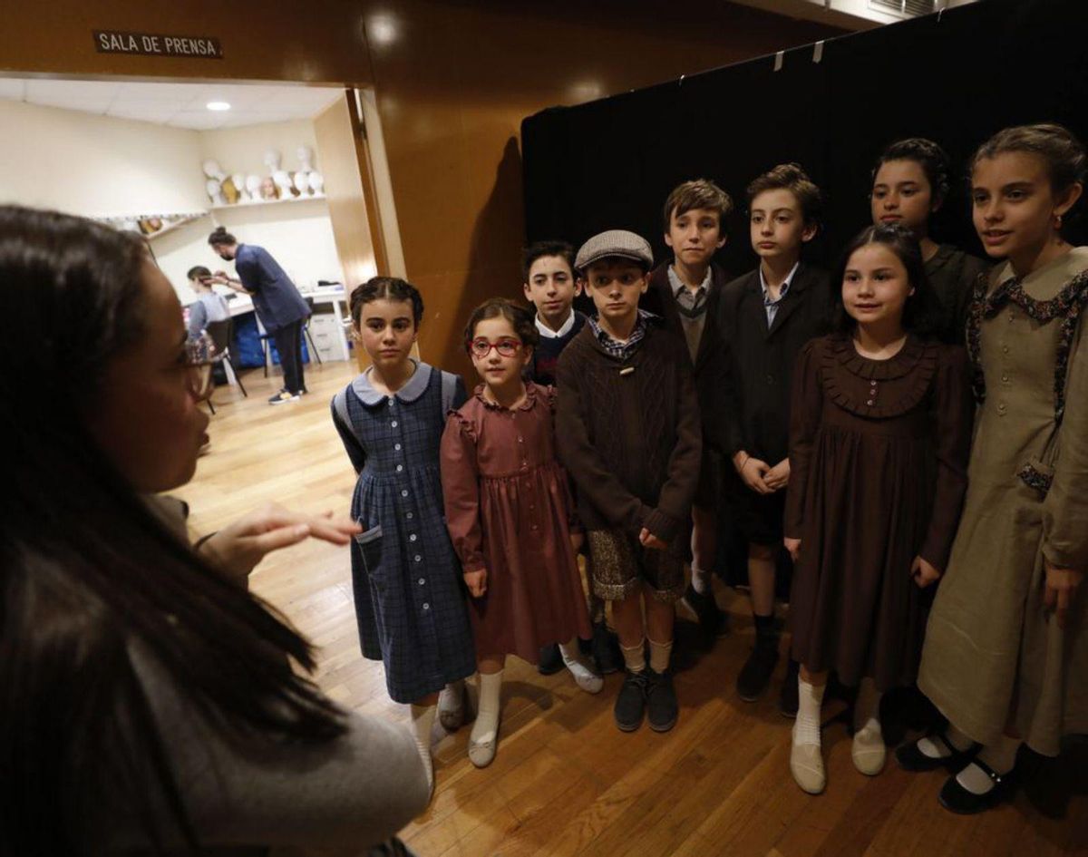 Dos momentos del ensayo: cantantes del coro infantil Divertimento y, a la derecha, Amelia Ochandiano pasa revista al coro con el vestuario. | Luisma Murias