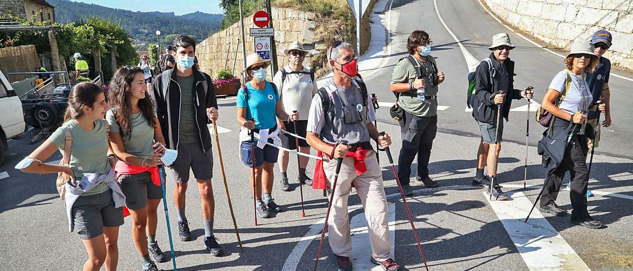 María del Carmen, con retinosis pigmentaria, enganchada a su marido, Carlos Velasco, por un artefacto construído por este para realizar el Camino Portugués, ayer a su paso por Mos.   | // ANXO GUTIÉRREZ