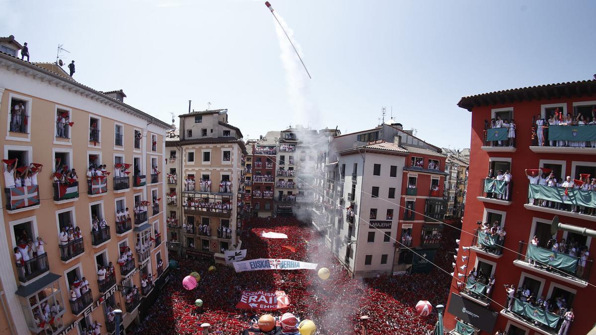 PAMPLONA, 06/07/2026.- Los Sanfermines 2026 han arrancado este mediodía con un chupinazo lanzado por dos representes de la Subdirección de Urgencias de Navarra, candidatura elegida por votación popular, en una jornada marcada por las altas temperaturas que llegarán a los 40 grados en la capital navarra. Desde el balcón del Ayuntamiento y ante miles de personas que desde horas antes esperaban ansiosas el momento, el director de la subdirección Clint Jean Louis y la enfermera de la UVI móvil de Tafalla Araceli Sergio, elegida en una votación interna por sus compañeros, han prendido la mecha del cohete anunciador con el tradicional mensaje de: "Pamploneses, pamplonesas, ¡Viva San Fermín! Iruindarrak, Gora San Fermín!". EFE/ Jesus Diges/ POOL