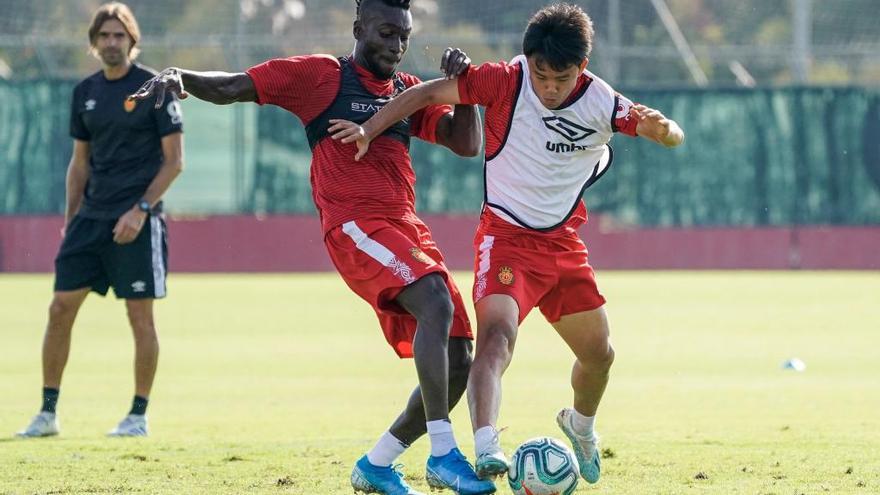 Lago Junior y Take Kubo pugnan por un balÃ³n en un entrenamiento.