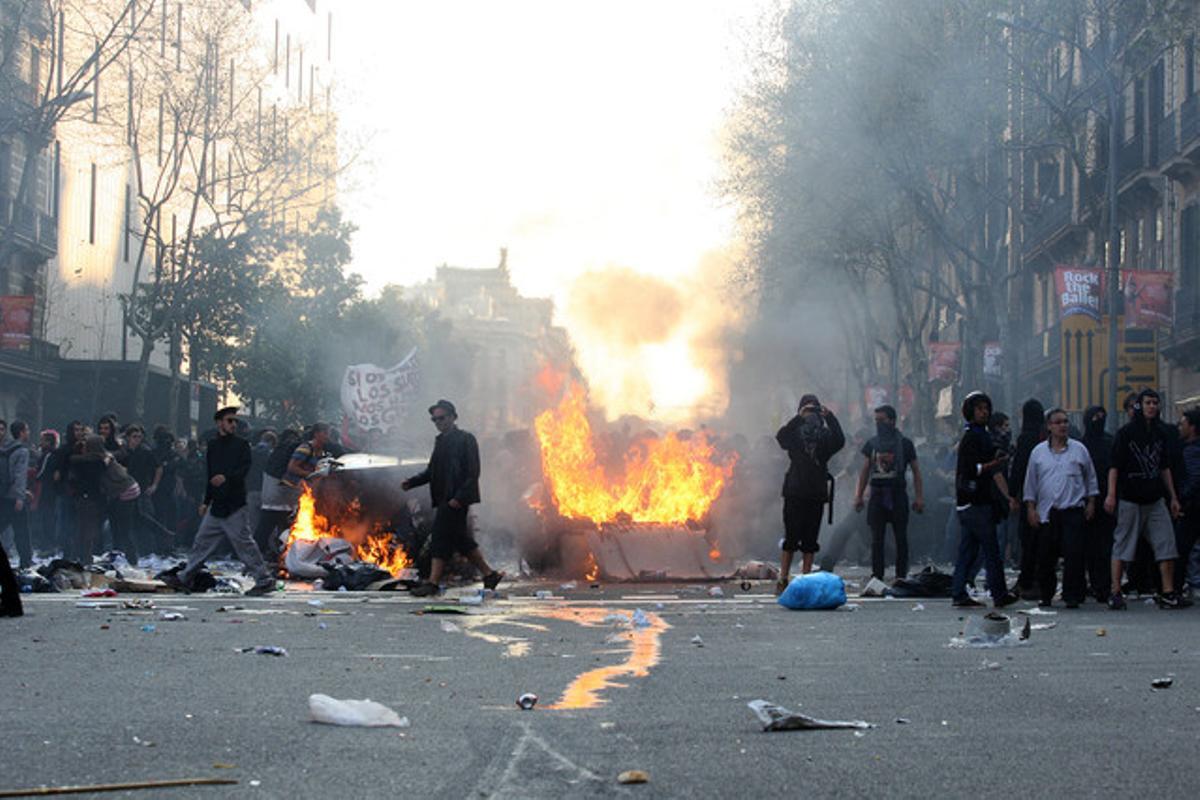 Contenedores incendiados en el centro de Barcelona después de la manifestacion contra la reforma laboral, en Barcelona.