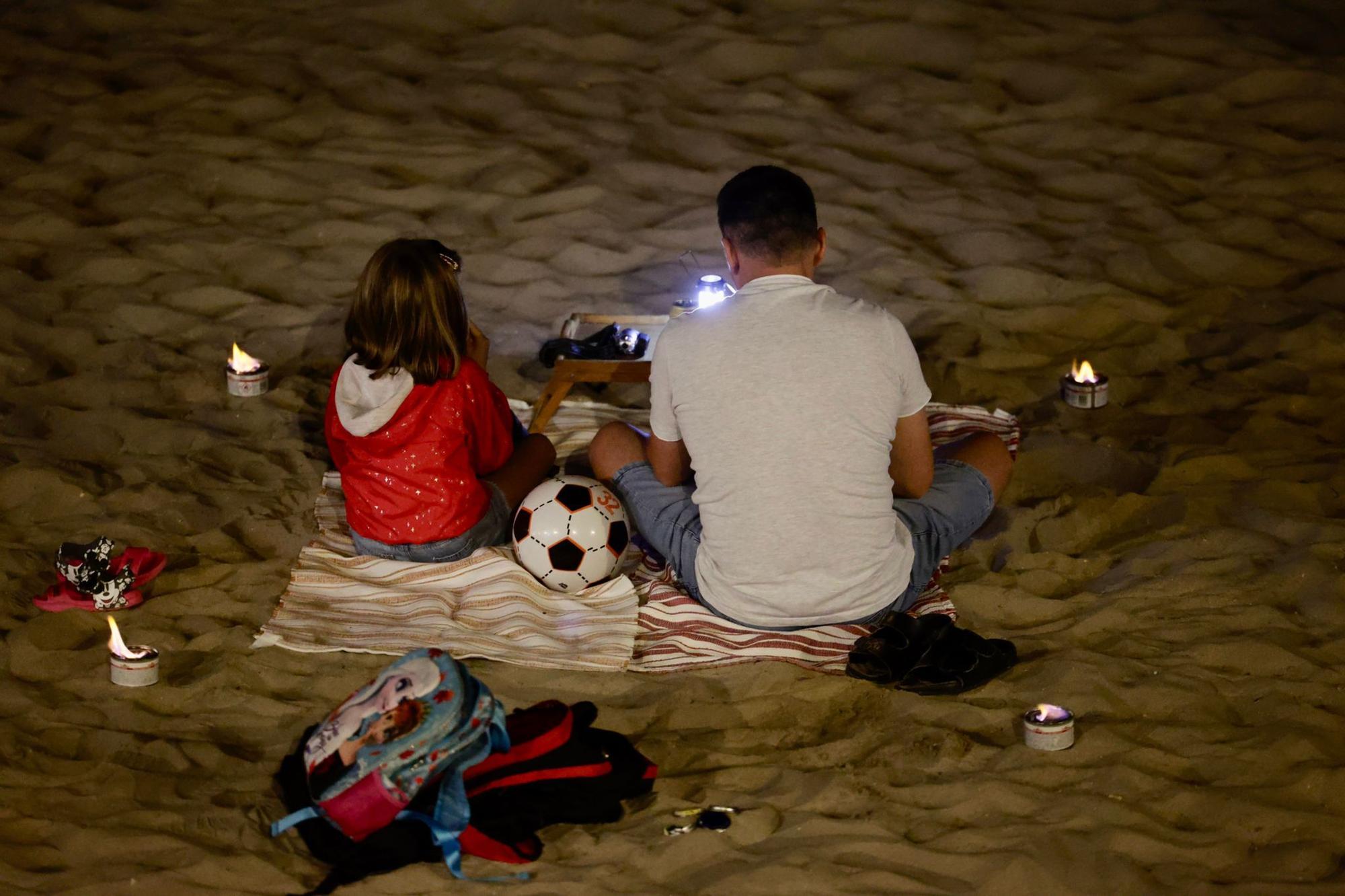 Muchas personas han encendido pequeñas velas en la playa ante la prohibición, un año más, de encender hogueras.
