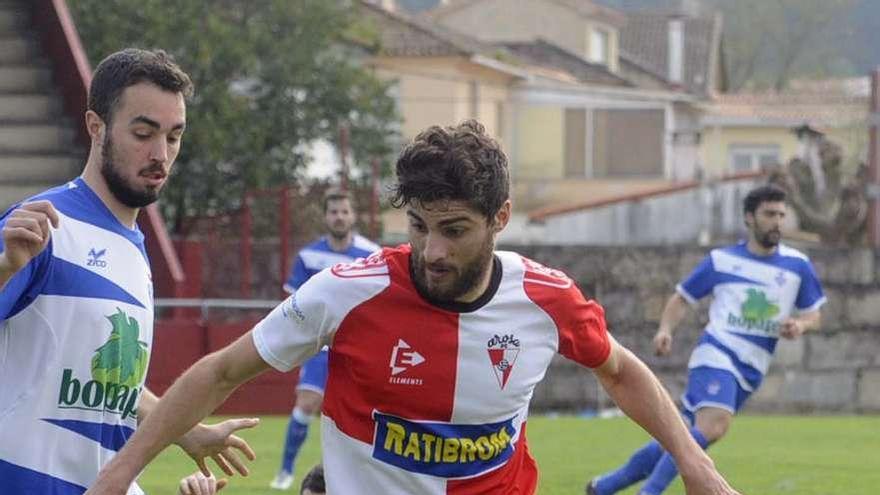 Nando trata de deshacerse de un contrario durante el partido disputado ayer en A Lomba. // Noé Parga