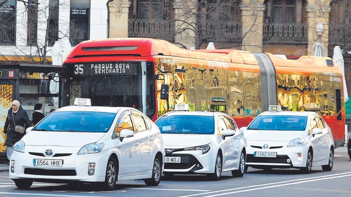 Tres taxistas circulan por el centro de Zaragoza.