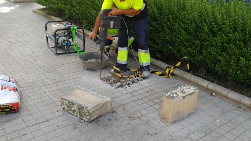 Operarios municipales retirando los bancos de piedra.