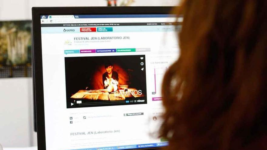 Una mujer observa la página goteo.org donde se puede colaborar con el festival.