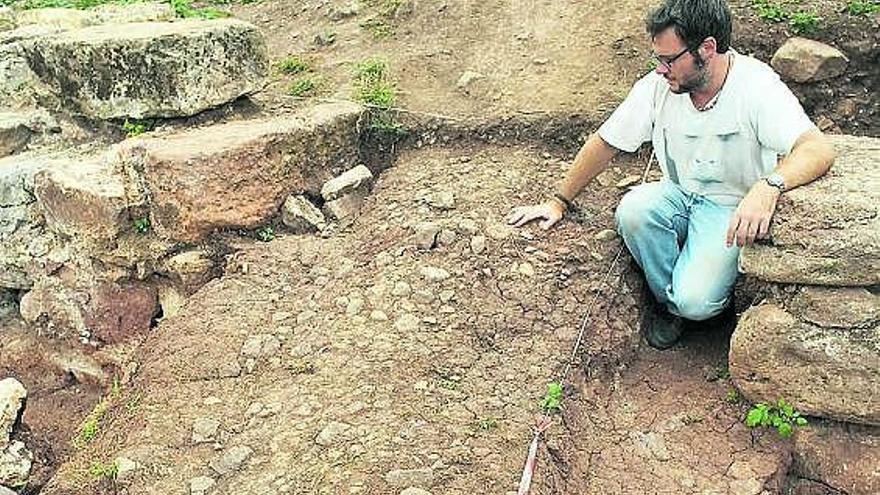 Iván Muñiz, ante la puerta de acceso y el pavimento original del Alto medievo formado por arcilla y piedras.