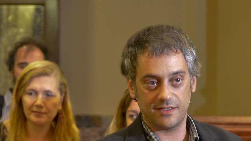 El alcalde, al entrar en el salón de plenos, ante algunos ediles.