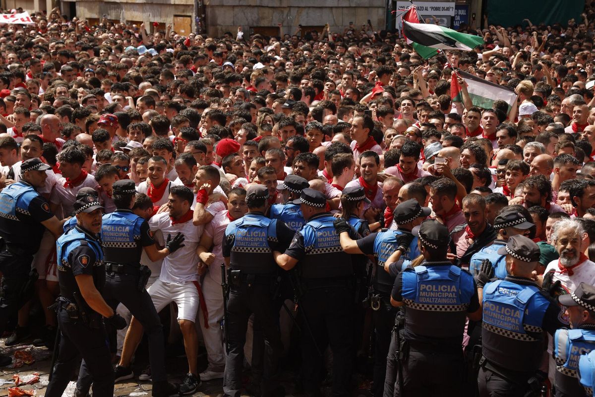 PAMPLONA, 06/07/2025.- Agentes de la Policía Municipal hacen espacio para que la Banda Municipal La Pamplonesa y los txistularis municipales interpreten la Biribilketa de Gainza en la Plaza Consistorial de Pamplona después del tradicional Chupinazo desde el balcón del ayuntamiento de la ciudad y que da comienzo a los Sanfermines, este domingo. EFE/ Villar López