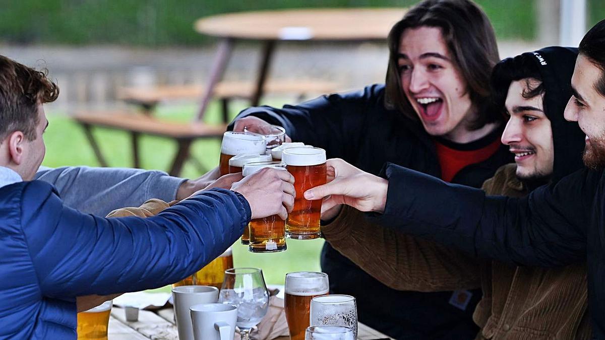 Un grupo de jóvenes brinda con pintas de cerveza, ayer, en la terraza de un pub de Londres.   | // ANDY RAIN